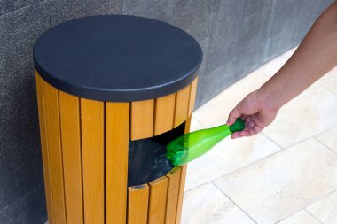 Boş plastik şişeyi geri dönüşüm çöpüne atmak.