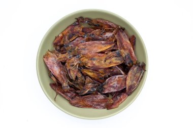 Beyaz arka planda yeşil kâsede kurutulmuş mürekkep balığı..