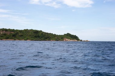 Mavi denizde bir ada. Mavi okyanus su yüzeyi dokusu. Yaz arkaplanı.