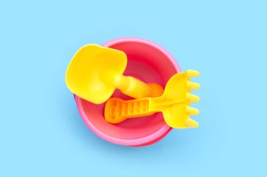 Açık havada plaj oyuncakları, mavi arka planda kürek dolu kovalar. Yaz arkaplanı kavramı