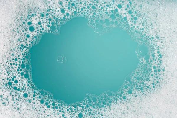 洗涤剂泡沫在水面上起泡 蓝色背景 肥皂水 — 图库照片