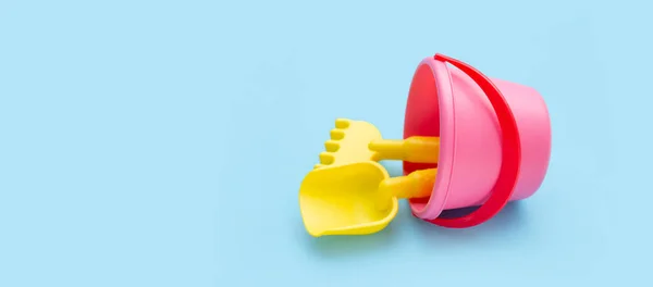 stock image Outdoor summer beach toys, shovel with shovel rake in bucket on blue background. Copy space