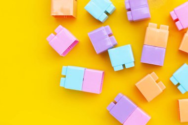 Sarı arka planda plastik yapı taşları. Üst görünüm