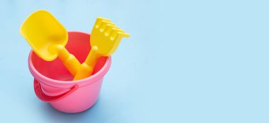Plastik oyuncaklar, mavi arka planda kürek dolu kovalar. Yaz arkaplanı kavramı