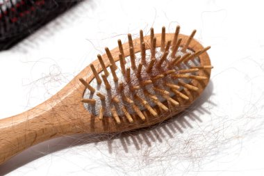 Beyaz arka planda saç dökülmesi.