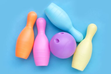 Mavi arka planda renkli plastik bowling oyuncağı.