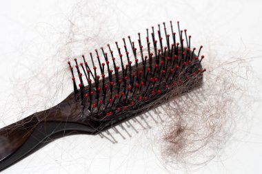 Beyaz arka planda saç dökülmesi.