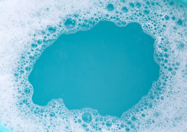 洗涤剂泡沫泡在水面上 蓝色背景 肥皂水 — 图库照片