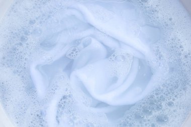Top view of towel soak in powder detergent water dissolution. Laundry concept