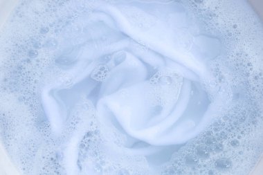 Top view of towel soak in powder detergent water dissolution. Laundry concept