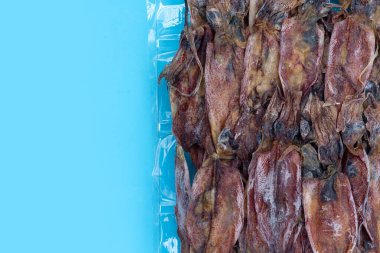 Mavi arkaplanda kurumuş mürekkep balığı.