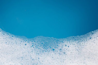 Deterjan köpüklü su. Mavi arkaplan, sabun suyu