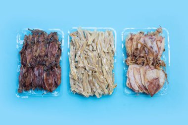 Mavi arka planda kurutulmuş ançüez ve kurutulmuş mürekkep balığı..