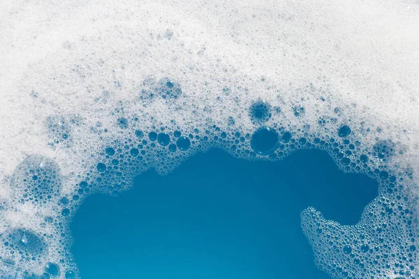 洗涤剂泡沫在水面上起泡 蓝色背景 肥皂水 — 图库照片