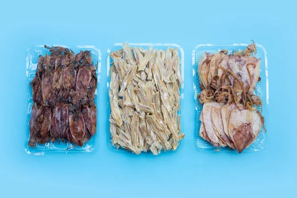 Mavi arka planda kurutulmuş ançüez ve kurutulmuş mürekkep balığı..