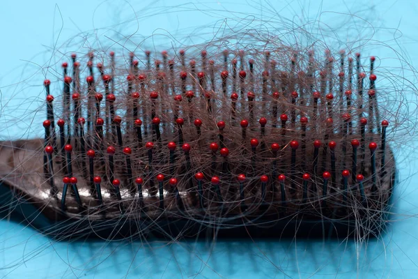 Mavi arka planda saç dökülmesi.