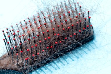 Mavi arka planda saç dökülmesi.