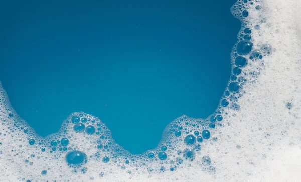 洗涤剂泡沫泡在水面上 蓝色背景 肥皂水 — 图库照片