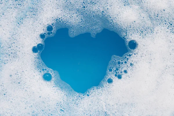 stock image Detergent foam bubble on water. Blue background, Soap sud