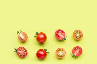 Taze domatesler, yeşil arka planda tam ve yarım kesik. Üst görünüm