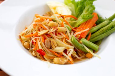 Beyaz tabakta baharatlı papaya salatası.