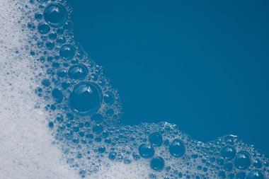 Deterjan köpüklü su. Mavi arkaplan, sabun suyu