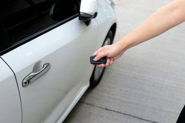 Arabayı kilitlemek ya da kilidi açmak için uzaktan kumandayı tutan el.