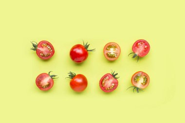 Taze domatesler, yeşil arka planda tam ve yarım kesik. Üst görünüm