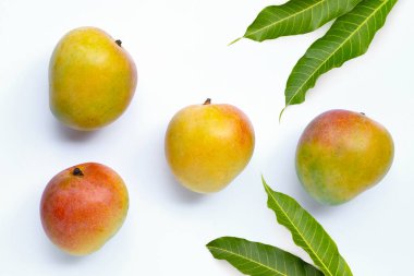 Tatlı ve sulu tropikal meyve, beyaz arka planda yeşil yapraklı mango. Üst görünüm