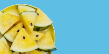 Mavi arkaplanda sarı karpuz dilimleri.