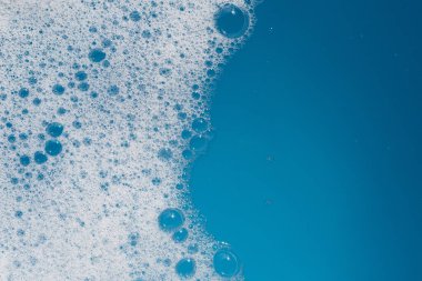 Deterjan köpüklü su. Mavi arkaplan, sabun suyu