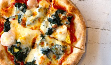 Beyaz ahşap masada pizza.