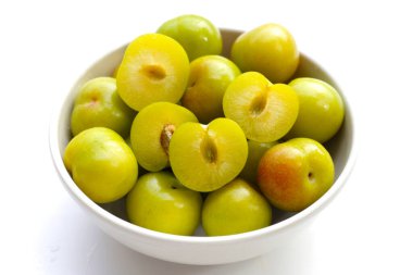 Beyaz arka planda taze yeşil erik meyvesi.