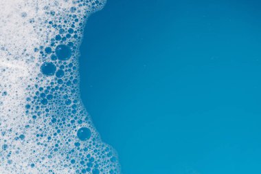 Deterjan köpüklü su. Mavi arkaplan, sabun suyu