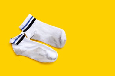 Sarı arka planda kirli beyaz çoraplar.