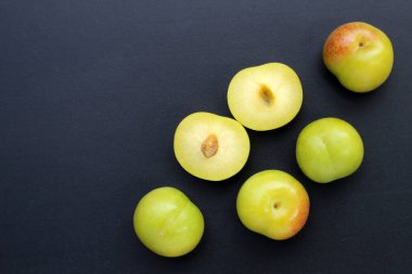 Koyu arkaplanda taze yeşil erik meyvesi.