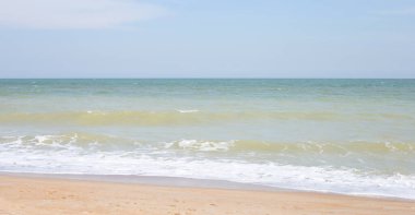 Deniz ve gökyüzü olan kumsal. Yaz tatili plajı