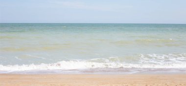 Deniz ve gökyüzü olan kumsal. Yaz tatili plajı