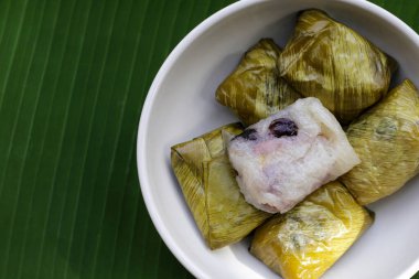 Muz yapraklarına sarılmış muz ve siyah fasulyeli haşlanmış pirinç.
