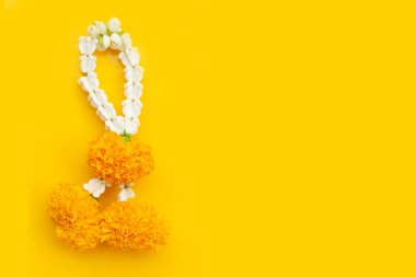 Sarı arka planda kadife çiçekli yasemin çelengi