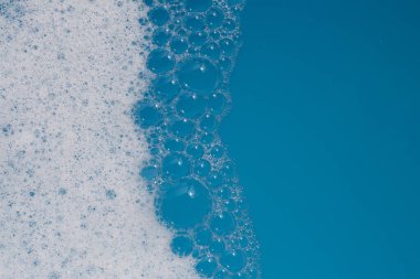Deterjan köpüklü su. Mavi arkaplan, sabun suyu