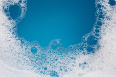Deterjan köpüklü su. Mavi arkaplan, sabun suyu