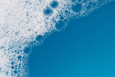 Deterjan köpüklü su. Mavi arkaplan, sabun suyu