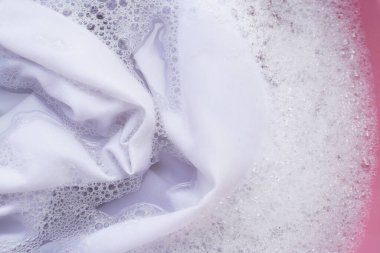 Çamaşır konsepti, suya batırılmış beyaz gömlek deterjan çözeltisi, çamaşır bezi.