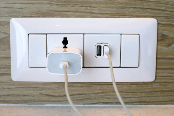Hand insert a plug of the phone charger into socket.
