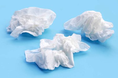 Buruşmuş kağıt mendil. Mavi arka planda yüz dokusu.