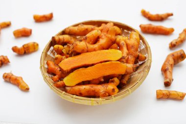 Beyaz arkaplanda zerdeçal kökleri.