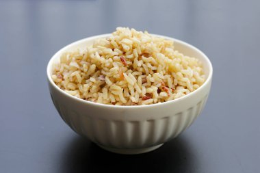 Koyu arkaplanda pişmiş kahverengi pirinç..