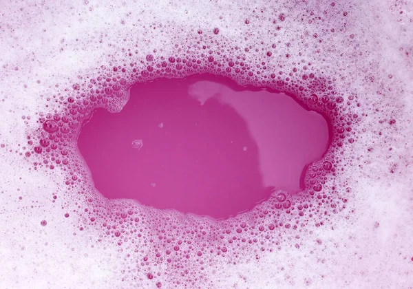 White detergent foam bubble, pink background.