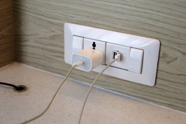 Elektrik prizi, prize takılı bir telefon.